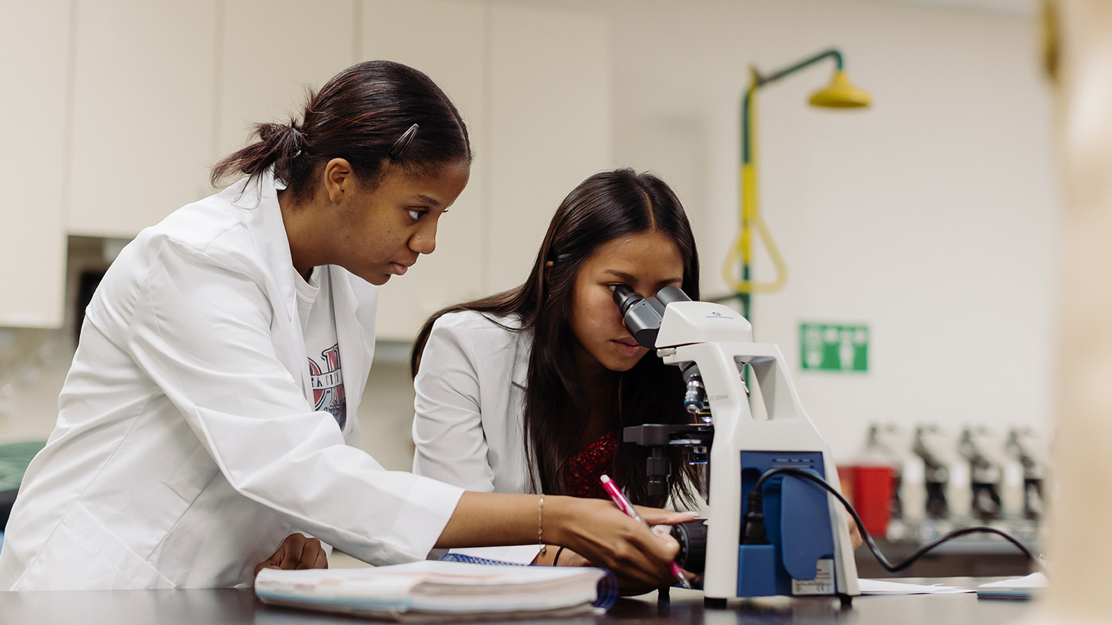 forensic science students looking through a microscope