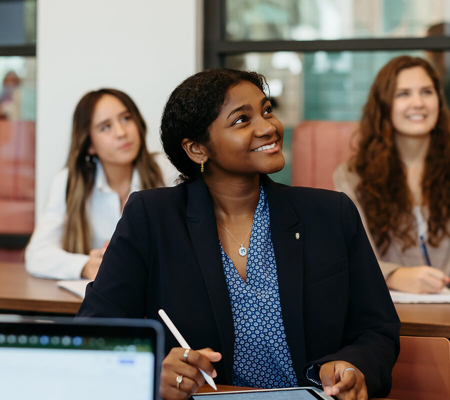 female students smiling and taking notes at Palm Beach Atlantic University