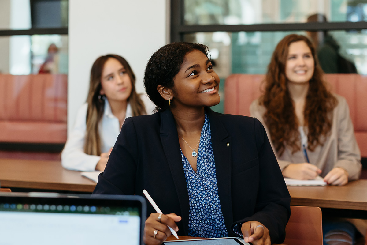 female students smiling and taking notes at Palm Beach Atlantic University