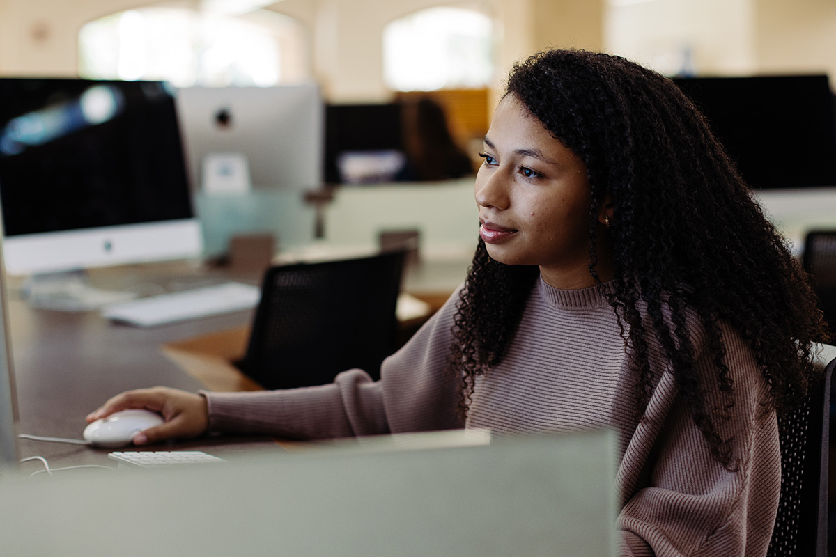 a graphic design student sitting at a computer