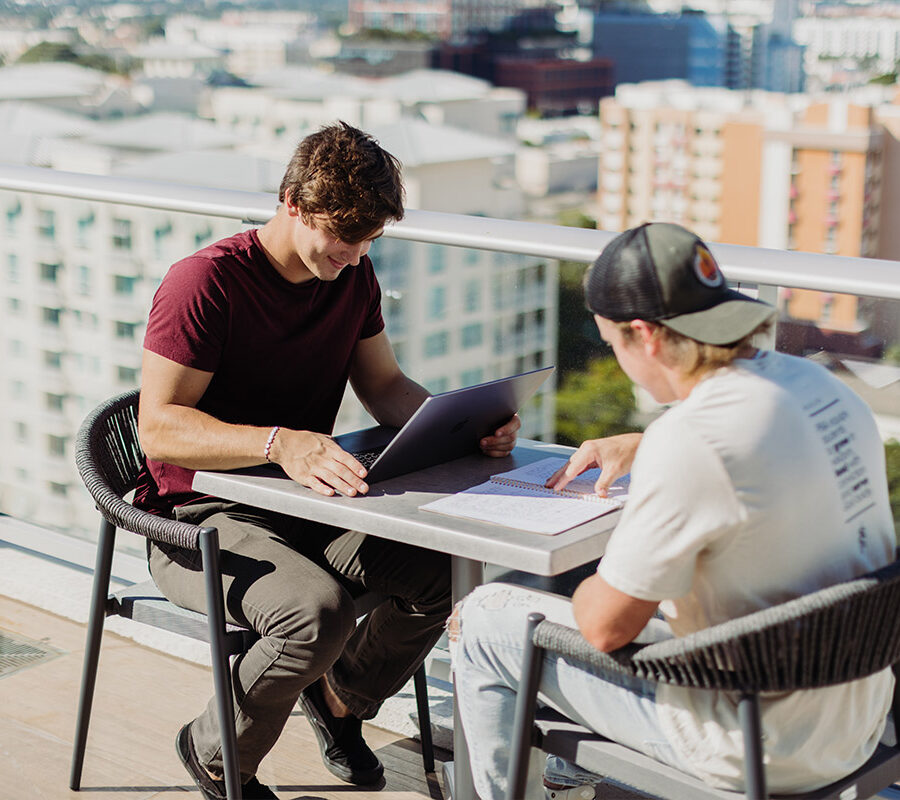 Two PBA students study on a rooftop.